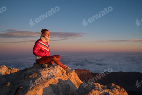 Preview: Woman enjoying sunrise listening music on teide volcano