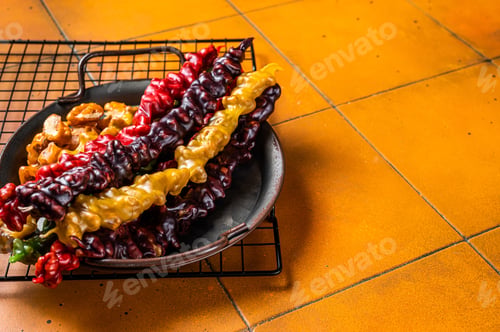 Preview: National Georgian sweets Churchkhela with walnut, hazelnuts. Orange background. Top view. Copy space