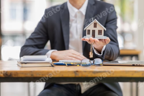 Preview: house model with businessman signs a purchase contract or mortgage for a buy and sell home insurance