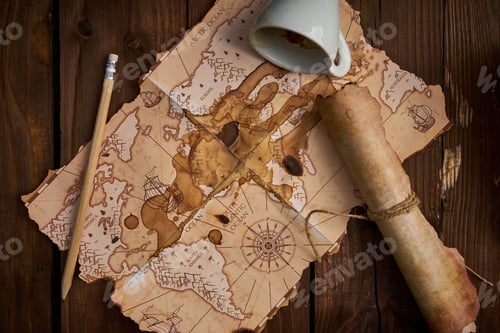 Preview: Aged parchment scroll, an old map, a pencil, and a spilled coffee cup on a wooden table.