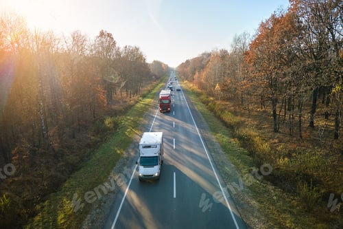 Preview: Aerial view of cargo trucks driving on highway hauling goods