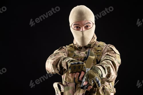 Preview: front view of young soldier in uniform reloading gun on black background israel tank warrior