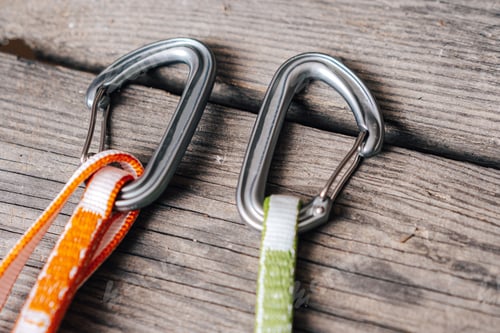 Preview: Sport climbing equipment like carabiners and slings on wooden background