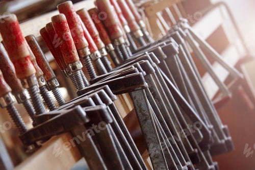 Preview: Row of carpenters clamps on workshop shelf