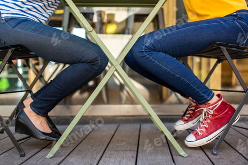 Preview: woman legs sitting at table with teen daughter legs
