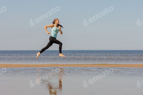 Preview: jogging, sporty woman runs in morning on seashore. fitness millennial female trains for marathon