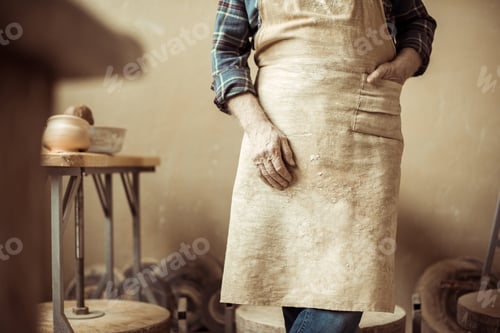 Preview: Cropped Image of Senior Potter in Apron Standing at Workshop