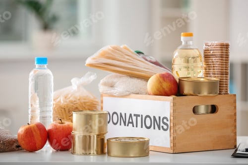 Preview: Donation box with food products on table indoors