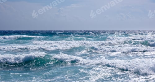 Preview: Rocky seashore with wavy ocean and waves crashing on the rocks. Stromy weather