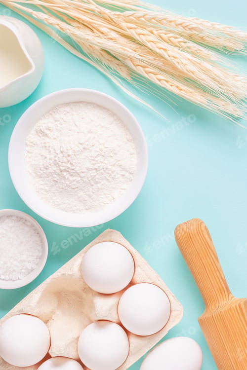 Preview: Ingredients for baking on light blue background.