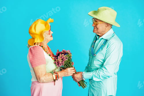 Preview: Beautiful senior old couple wearing fancy party clothes acting in studio on a colored background.