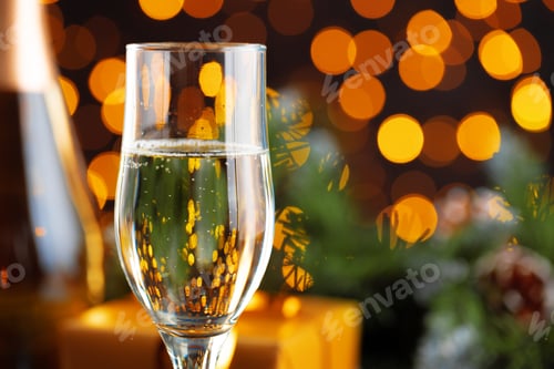 Preview: Champagne glass on blurred garland lights background