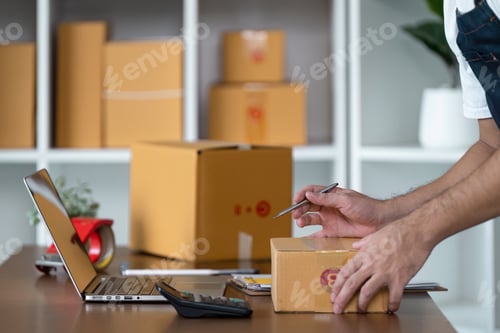 Preview: Entrepreneur Packing Orders in Home Office for Small Business E-commerce with Laptop and Cardboard