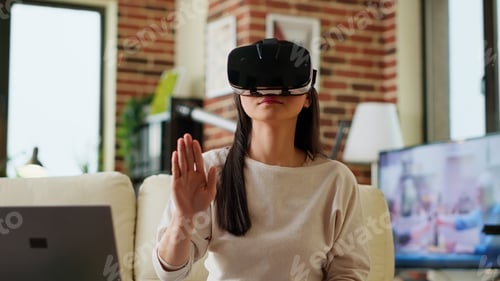 Preview: Asian person wearing futuristic VR goggles while interacting with cyber reality.