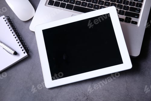 Preview: Top view of digital tablet, laptop and notepad on table