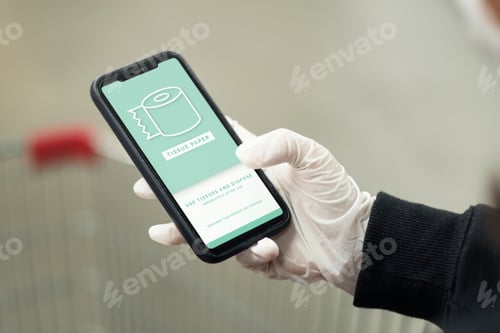 Preview: Woman wearing a latex glove while using cellphone to prevent coronavirus contamination mockup screen