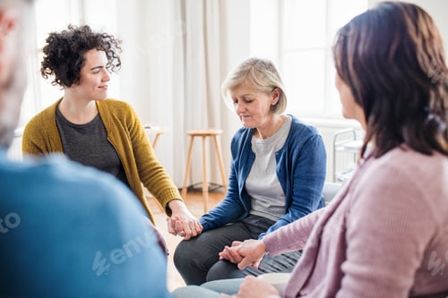 Preview: Men and women sitting in a circle during group therapy, supporting each other.