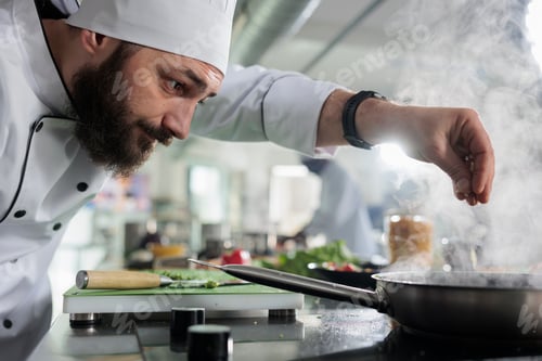 Preview: Gastronomic expert in professional kitchen seasoning gourmet dish served at fine dining restaurant.