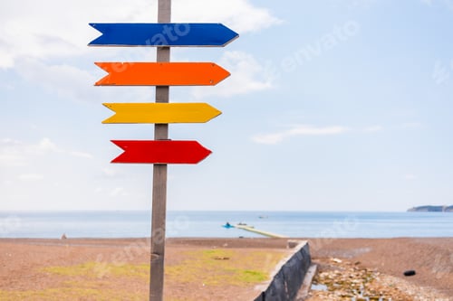 Preview: Wooden beach signpost with arrows on seaside promenade, copy space. Summer vacation