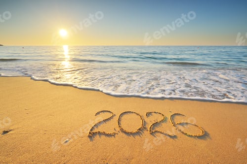 Visualização: Símbolo de texto de 2026 do ano novo na praia de areia do mar durante o pôr do sol.