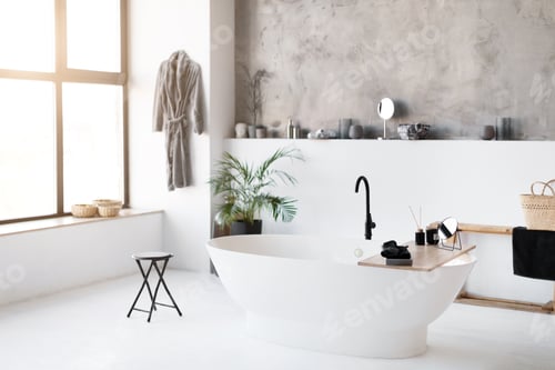 Preview: Interior shot of spacious, sunlit bathroom featuring sleek freestanding bathtub