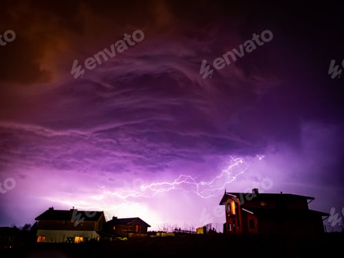 Preview: Valley with houses on it under a cloudy sky during storm in the night