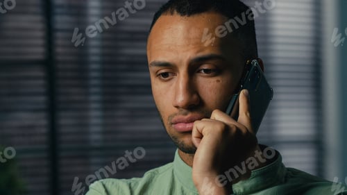 Preview: Serious worried excited latin american man talking mobile phone sad frustrated confused young