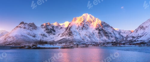 Preview: Beautiful snow covered mountains and blue sky reflected in water
