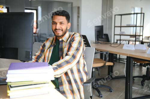 Preview: Happy indian male student at the library