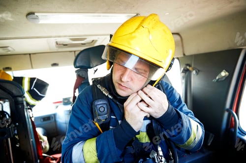 Preview: Fireman putting on helmet in fire engine