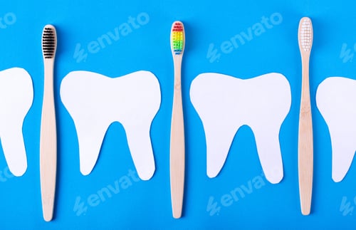 Preview: Paper teeth and bamboo toothbrushes on blue