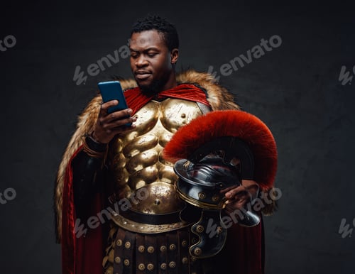 Preview: Black man in roman soldier costume using smartphone