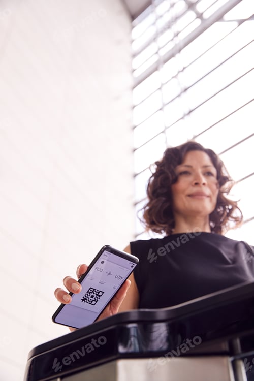 Preview: Businesswoman In Airport Departure Lounge Scanning Digital Boarding Pass On Smart Phone