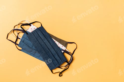 Preview: Top view of heap of protective cotton masks on orange background. Protect your health