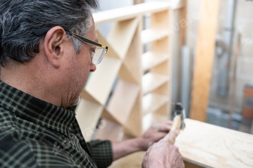 Preview: Overhead view of elderly carpenter using a hammer