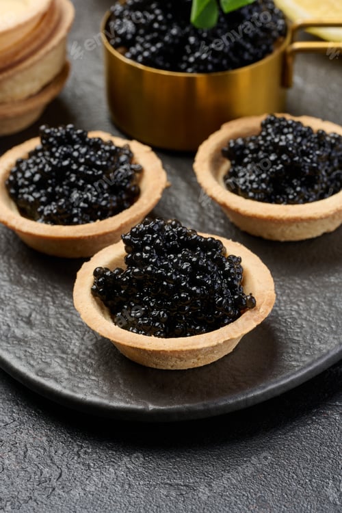 Preview: Black sturgeon caviar in round tartlets on table, top view