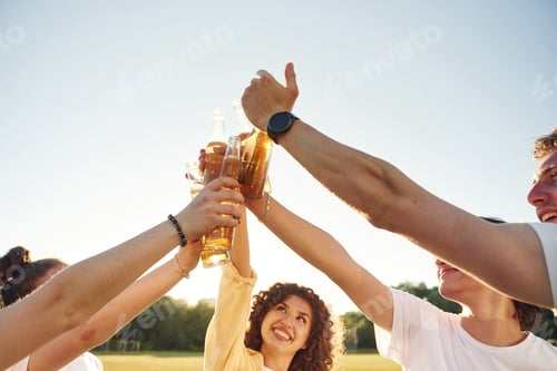 Preview: Party time, celebration. People are celebrating by cheering with beer bottles
