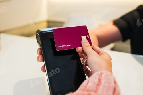 Preview: Customer paying with contactless credit card at clinic reception