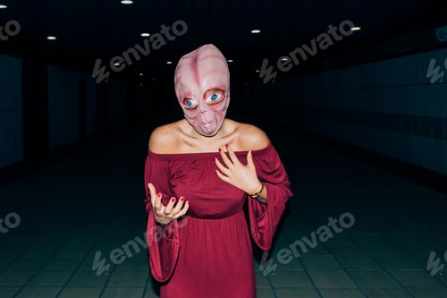 Preview: young woman indoor wearing alien mask