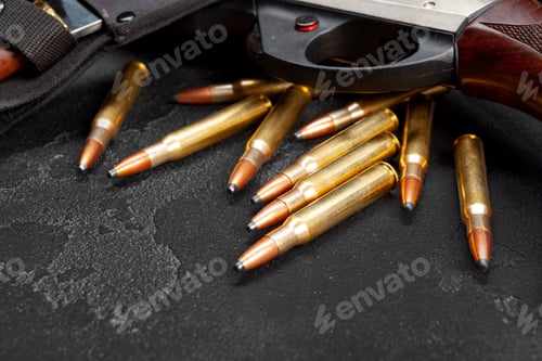 Preview: Close up of hunting shotgun and cartridges on dark grey background