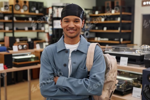 Preview: Black young man standing in music store and looking at camera
