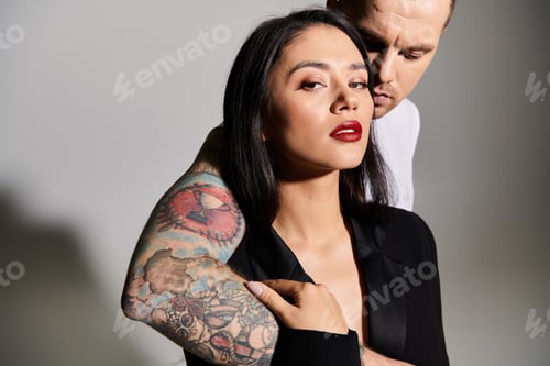 Preview: Young couple embraces passionately, showcasing love and fashion in a modern studio environment.