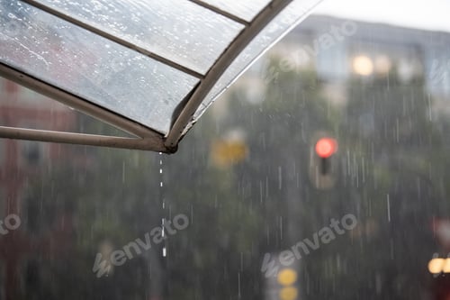 Preview: Heavy rain is dripping from the roof while a red traffic light shines