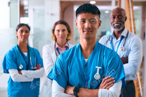 Preview: Portrait Of Smiling Multi Cultural Medical Team Wearing Scrubs And White Coats In Modern Hospital
