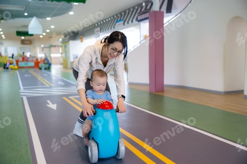 Preview: Mother ride toy car with little son indoor playground
