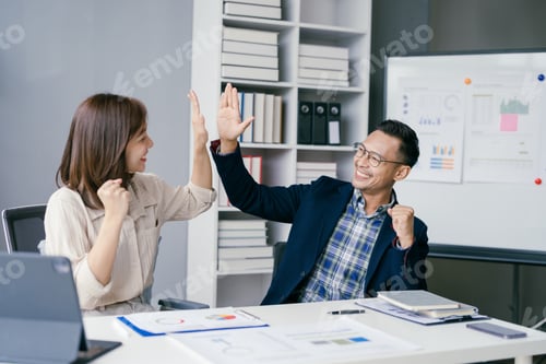 Preview: Business Colleagues Celebrating Success with High Five in Modern Office Environment