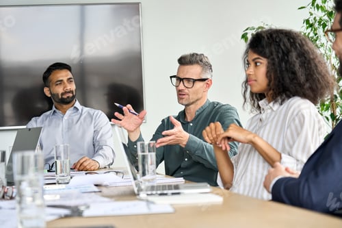 Preview: Mature mentor manager speaking at executive team meeting in boardroom.
