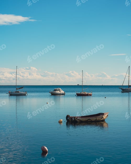 Preview: sailboats and buoys resting in the calm waters of a lake