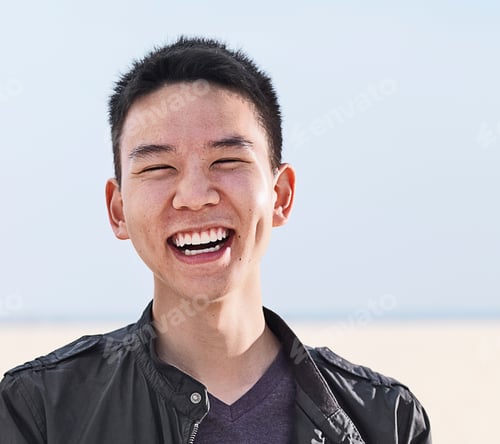 Preview: Portrait of smiling young man at beach