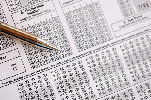 Preview: Blank educational test for students lies on table in classroom with pen